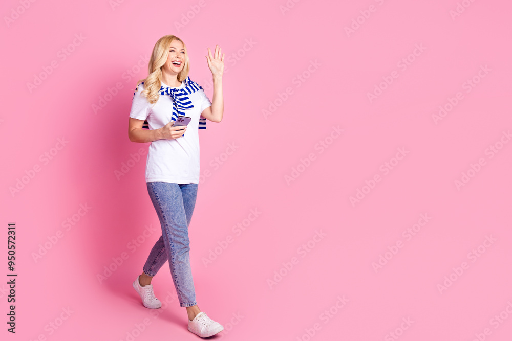 Poster full size photo of pretty young female walking wave hand hi hold device wear trendy white outfit iso