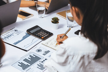 Diverse corporate audit team or company bookkeeper and accountant consultant calculate account expenses and income budget for tax refunds using calculators in busy workspace. Prudent