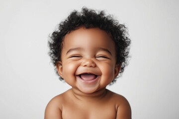 chubby curly-haired black baby 3 months old smiles strongly on white background