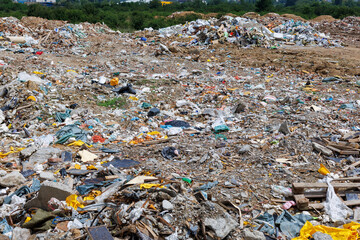 Construction debris pile at a disposal site with scattered waste materials during daylight