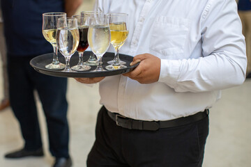 Waiter carrying a tray of assorted drinks at a formal event