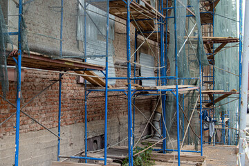 Scaffolding covered with protective net. Protection from falling construction debris
