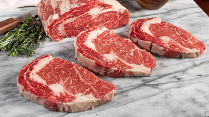 Closeup of freshly cut raw steaks on a kitchen counter.
