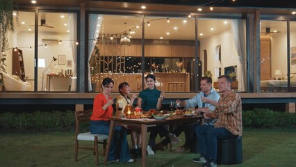 Happy family holding glowed sparkler in holiday celebration party at night. Lovely member enjoy playing spark toy together. Outdoor activity to cross generation gap strengthen family bond. Divergence.