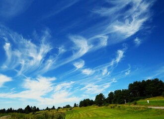 Howling clouds over green fields