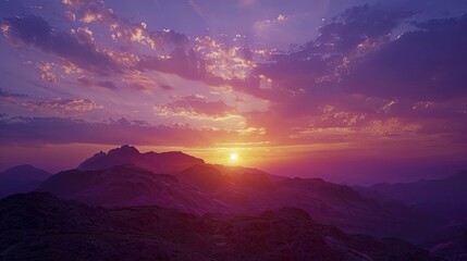 Fototapeta premium A stunning sunset behind a mountain range with the sky painted in shades of purple and gold.