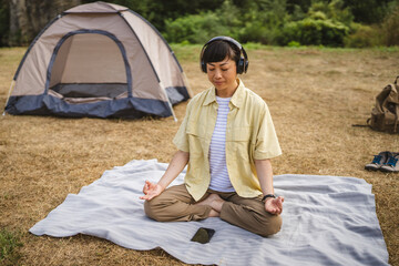 Japanese woman practice guided meditation manifestation in front tent