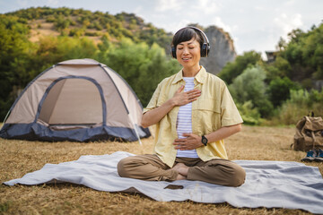Japanese woman practice guided meditation manifestation in front tent