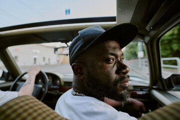 Medium close up of man sitting in front seat and looking back
