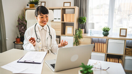 Japanese woman doctor have video consultation via laptop about pills