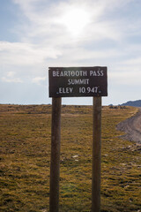 Vertical image of Beartooth Pass sign on scenic Beartooth Highway 212 in Wyoming during summer.

