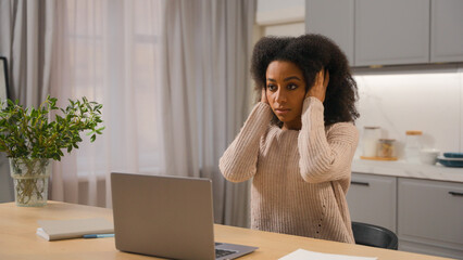 Annoyed angry woman African American businesswoman freelancer online working laptop at home kitchen...