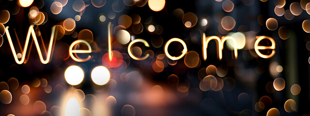 The text “Welcome” against a blurry background of lights. Welcome concept, signage at the entrance.