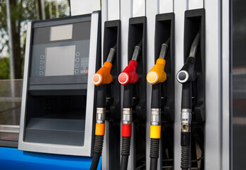 Fuel dispensers at a gas station during the day with pricing display clearly visible. Fuel...