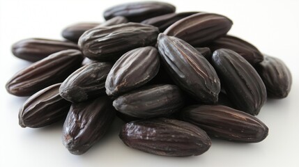 Obraz premium a pile of dark brown tonka beans with a smooth surface and visible textural details. These beans are commonly used as a flavoring agent in culinary applications.