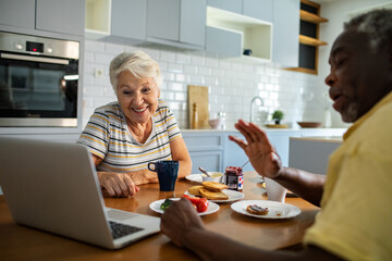 Senior couple video calling family during breakfast