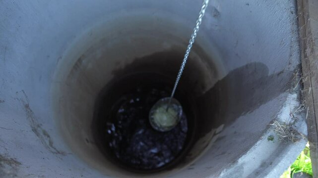Fetching water from well by hand, fresh pure drinking mineral water.