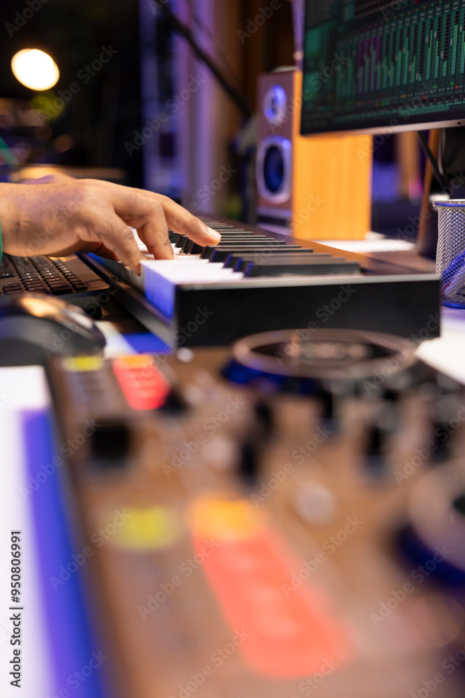 Poster artist composer playing a track on midi controller in home studio, adding piano notes on an old audi