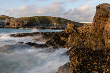 Waves crashing on rocks at newquay beach in cornwall, england