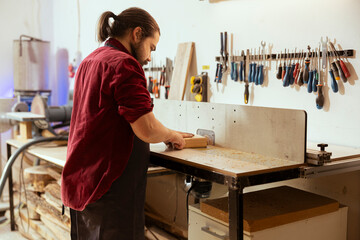Skilled carpenter meticulously operating wood shaper in assembly shop, creating intricate designs with precision. Cabinetmaker uses spindle moulder to shape and mold wooden pieces