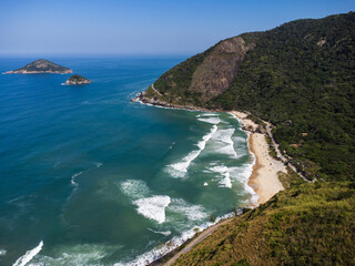 Aerial view of Prainha Beach, a paradise in the west side of Rio de Janeiro, Brazil. Big hills around. Sunny day. Greenish sea. Drone Photo