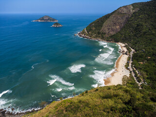 Aerial view of Prainha Beach, a paradise in the west side of Rio de Janeiro, Brazil. Big hills around. Sunny day. Greenish sea. Drone Photo