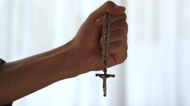 Sense of devotion and spiritual fulfill with christian catholic follower immerse in faith. Slow motion hand hold holy cross for religious prayer with strong determination. Burgeoning