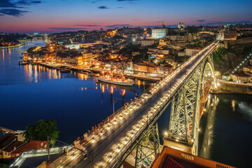 View of illuminated Porto city and Douro river and Dom Luis bridge I from famous tourist viewpoint...