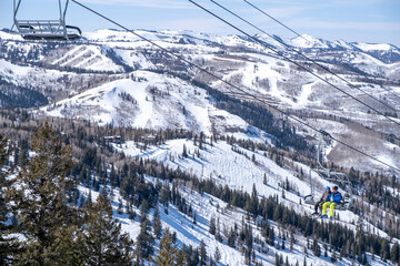 Two skiers on a chair lift smiling isolated, Deer Valley, Park City, UT, USA, March 25, 2022