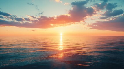 Fototapeta premium A sunrise over a calm ocean, with the colors of the sky reflecting on the water, slowly transitioning into dusk