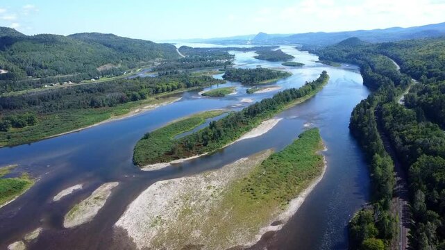 Vue a&eacute;rienne des &icirc;les verdoyantes &agrave; l'embouchure de la l&eacute;gendaire Rivi&egrave;re Restigouche. Rivi&egrave;re &agrave; saumon au d&eacute;cor idyllique r&eacute;put&eacute;e mondialement &agrave; vue de drone.  ( Nouveau-Brunswick / Qu&eacute;bec )