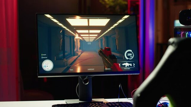 Shooting videogame on PC with neon lights illuminated components in empty apartment. Science fiction game on desktop PC monitor next to virtual reality glasses and computer peripherals