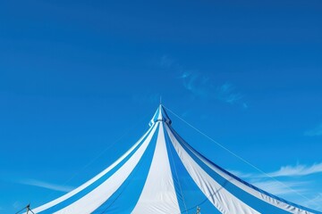 Obraz premium Blue and white striped circus tent under clear sky