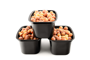 fresh hazelnuts in plastic black containers, group of objects