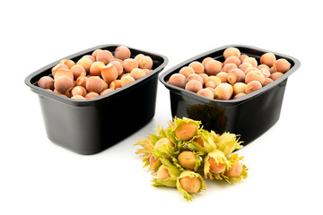 fresh hazelnuts in plastic black containers, group of objects