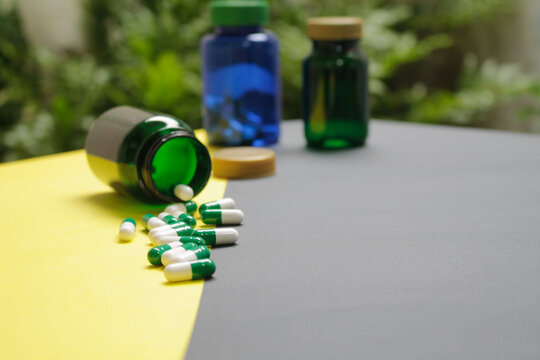 capsulas para la salud con recipientes al fondo.