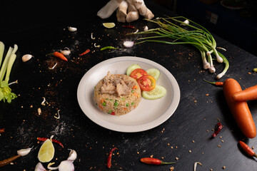 Elevate your meal with this savory pork fried rice, served with a side of fresh cucumber and tomato.
