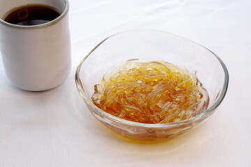 ガラスの器に盛りつけたところてんと麦茶の写真