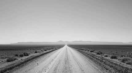 Desert road under a clear sky, minimalist, monochrome, high contrast, endless journey