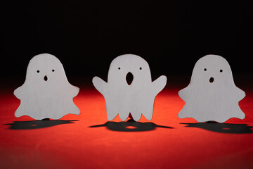 tres fantasmas de halloween asustando kawaii, iluminados con luz roja y fondo negro 