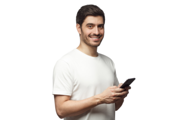 Young man looking and smiling at the camera with cheerful expression while texting to friend, using mobile phone