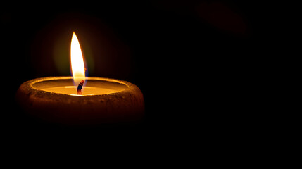 A single candle burning brightly, with one side of the image showing the warm, glowing light illuminating a small area, gradually blending into the surrounding darkness 