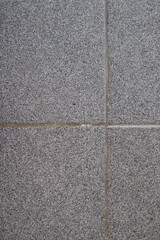 Close-up of a gray textured wall with grout lines.