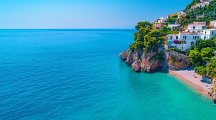 Obraz premium Stunning coastal view featuring crystal clear water, rocky cliffs, and vibrant greenery under a clear blue sky.