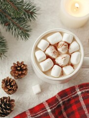 Top-view vertical photo of hot beverage, marshmallows, candle, spices, pine cone, and a red plaid on a soft beige background, 