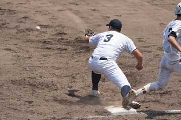 送球を受ける一塁手とセーフになったランナーの足