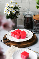 Kuih Lapis, a traditional Malay layered steamed cake and dessert, in white plates.