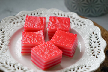 Kuih Lapis, a traditional Malay layered steamed cake and dessert, in white plates.