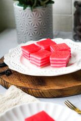 Kuih Lapis, a traditional Malay layered steamed cake and dessert, in white plates.