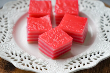 Kuih Lapis, a traditional Malay layered steamed cake and dessert, in white plates.